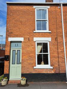 Character Beverley Town House في بيفرلي: كلب ينظر من نافذة مبنى من الطوب