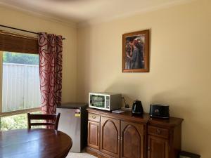 una habitación con una mesa y un microondas en un armario en James Court Suite, en Rutherglen