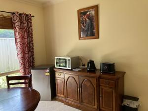 een kamer met een houten kast met een magnetron erop bij James Court Suite in Rutherglen