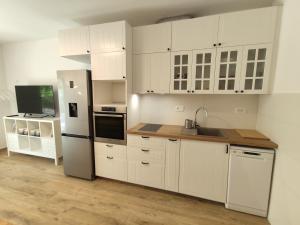 a kitchen with white cabinets and a white refrigerator at Apartman-studio, Salamunic, Pelinje, Jelsa in Jelsa