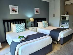 - 2 lits dans une chambre d'hôtel avec 2 lits dans l'établissement Tropical Seaside Suite 8, à East London
