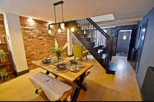 a dining room with a table and a brick wall at Boutique cottage set in historic town of Clitheroe in Clitheroe