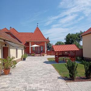 a patio with a table and a bench in a yard at L&iacute;via Apartman in B&uuml;k