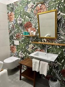 a bathroom with a sink and a toilet and a mirror at Hotel Sabrina in Castiglione della Pescaia
