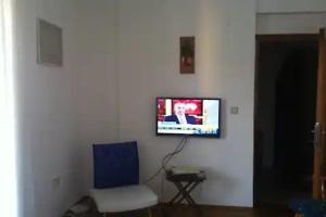 a room with a chair and a tv on a wall at LUXURY FLAT WITH A SEAVIEW — 800M TO BEACH PARK, 1KM TO MALL in Antalya