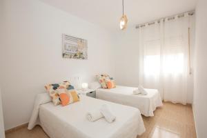 a white room with two beds and a window at Cristina IV in Campoamor