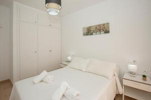 a white bedroom with a bed with towels on it at Cristina IV in Campoamor