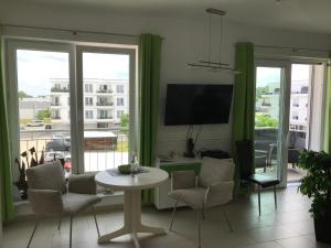 a living room with a table and chairs and a television at Zernsee-Perle an der Hafenpromenade in Werder in Werder