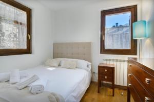 1 dormitorio con 2 camas, vestidor y ventana en Alojamiento Villanua Pirineos, en Villanúa