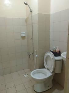 een badkamer met toilet met deksel bij Studio for Rent near Ortigas Extension in Cainta