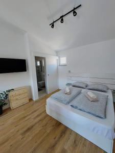 1 dormitorio blanco con 1 cama grande y TV de pantalla plana en Climber, en Starigrad-Paklenica