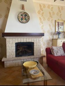 uma sala de estar com lareira e um sofá vermelho em Villa Di Caro em Ravanusa