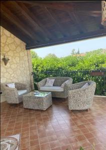 um pátio com 2 cadeiras de vime e uma mesa em Villa Di Caro em Ravanusa