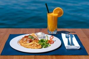 a plate of food on a table with a drink at Seafront apartments in Tivat