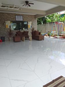 een woonkamer met een grote tegelvloer en een speeltuin bij Studio for Rent near Ortigas Extension in Cainta