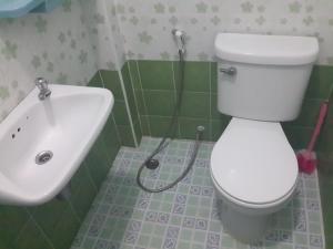 a bathroom with a white toilet and a sink at Chaiwat Resort in Laem Sing