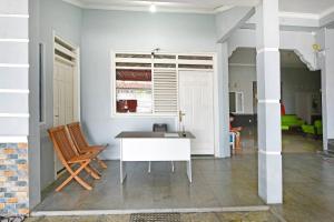 OYO Life 91399 Homestay Trendy Syariah في سيلاكاب: غرفة بيضاء فيها طاولة وكراسي