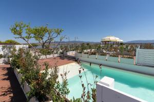 a view of a swimming pool on top of a building at New Bussola - Suites and Beach Club Cagliari Poetto in Poetto