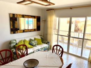 a living room with a couch and a table with chairs at Chez Marina in Les Cases d'Alcanar