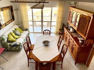 a table and chairs in a living room with a couch at Chez Marina in Les Cases d'Alcanar