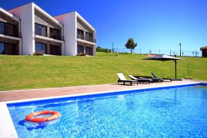 una piscina con una boa rossa di fronte a un edificio di Monte Bela Vista a Macedo de Cavaleiros