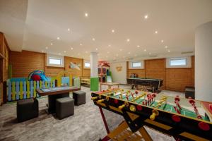 a childrens room with a pool table and play equipment at Lerchs Landhotel in Sankt Johann im Pongau