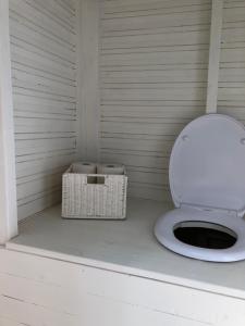 a toilet in a room with a basket next to it at Glampingtält in Torsby