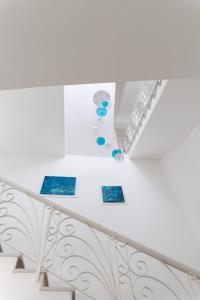 Un escalier blanc avec des photos bleues sur le mur dans l'établissement Hotel San Francesco, à Ischia