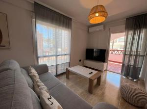 a living room with a couch and a tv at Las Palmeras in Benalmádena