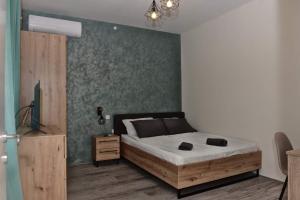 a bedroom with a bed and a green wall at 4-teen in Jagodina