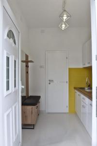 a white kitchen with a door and a sink at 4-teen in Jagodina