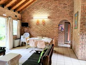 a room with a brick wall and a table and chairs at St Lucia Wilds in St Lucia