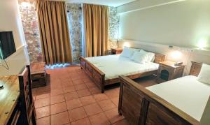 a hotel room with two beds and a television at Simosmare Resort in Elafonisos
