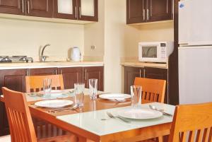 a kitchen with a table with chairs and a microwave at Golf Porto Marina Hotel Apartments Al Alamein in El Alamein