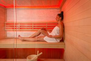 a woman is sitting in a sauna at Hotel Corner in Split
