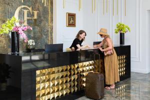 two women standing at a counter in a lobby at Hotel Corner in Split