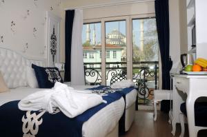 ein Schlafzimmer mit einem Bett und einen Balkon mit einem Gebäude in der Unterkunft Sarnic Premier Hotel in Istanbul