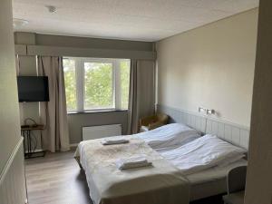 a bedroom with a bed and a television in it at Sørreisa Hotell in Nordstraumen