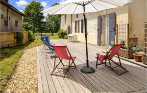 two chairs and an umbrella on a wooden deck at Stunning Home In Laruscade With Wifi in Laruscade