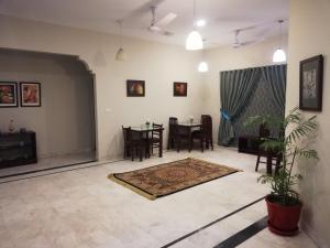 a living room with a table and chairs at Hotel island Clifton in Karachi