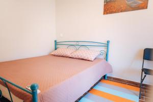 a bedroom with a bed with a blue frame at Edyta's Apartment in Pyrgi