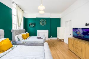 a living room with two beds and a flat screen tv at Pimlico Hub in London