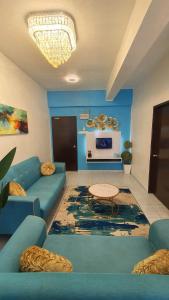 uma sala de estar com sofás azuis e uma mesa em D'MANGO COTTAGE MELAKA HOMESTAY BANDAR HILIR DAN KLEBANG em Malaca