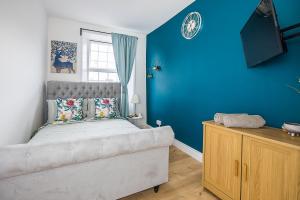 倫敦的住宿－Pimlico Hub，一间卧室设有一张床和蓝色的墙壁