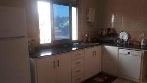 a kitchen with white cabinets and a sink and a window at Appartements proches de la mer Boukidan Al Hoceima in Al Hoceïma +6 photos