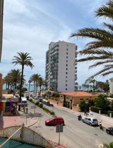 a street with palm trees and a tall building at Las Palmeras in Benalmádena
