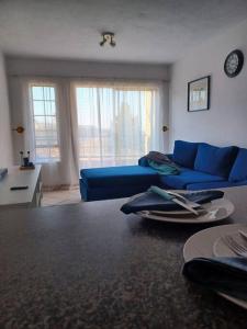 a living room with a blue couch and a table at The cozy 1 bedroom apartment in Midrand