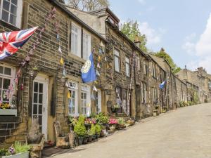 a row of houses with flags on a street at Penistone View in Keighley
