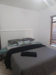 a bedroom with a large bed and a window at The cozy 1 bedroom apartment in Midrand