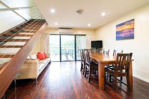 a living room with a dining room table and a staircase at Halls Gap Townhouse Escape in Halls Gap